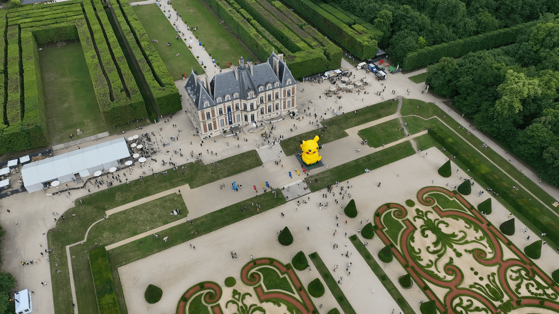 Vue aérienne d'un événement public dans un parc de château avec ballon géant