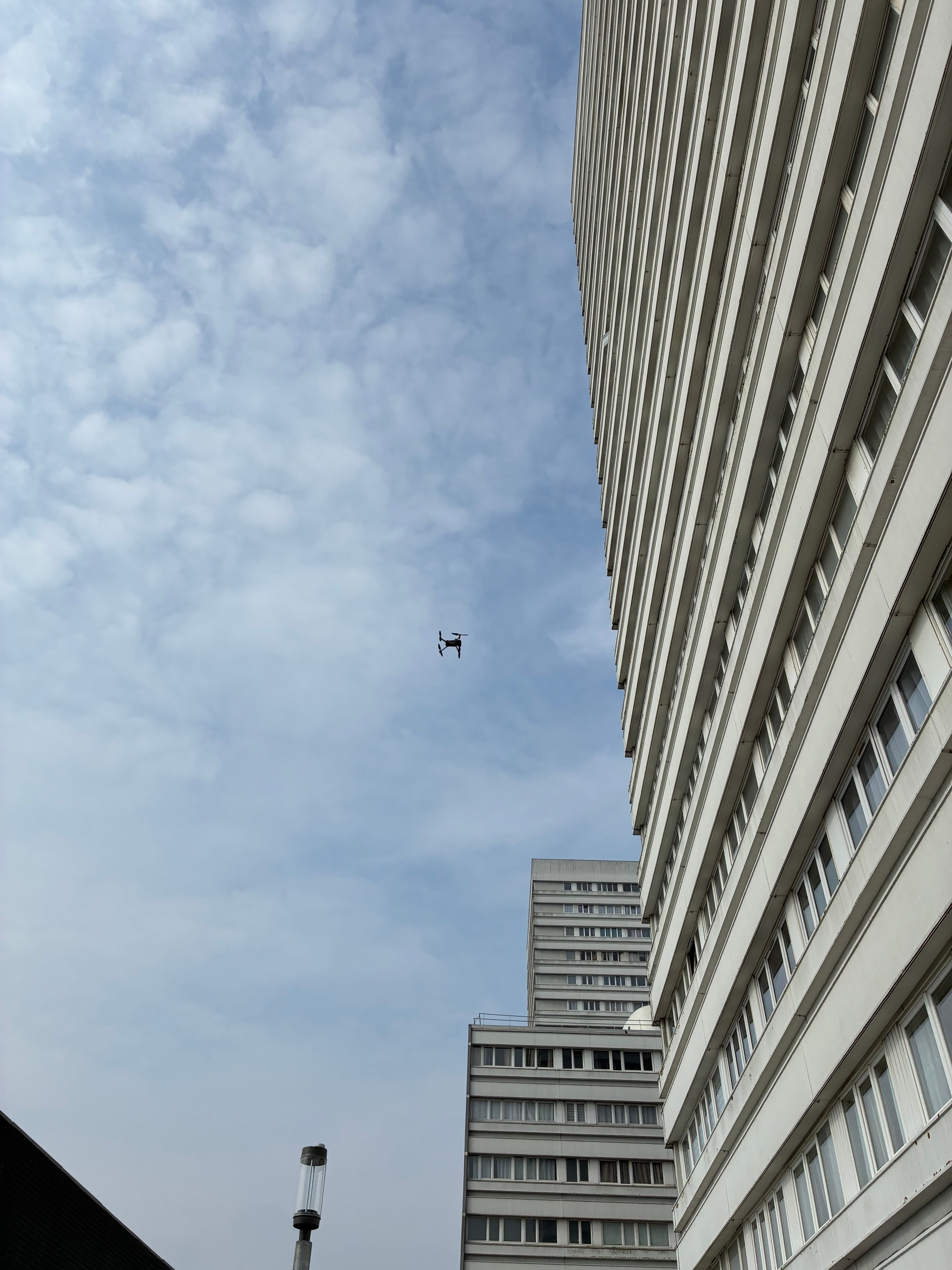 Drone en vol entre deux bâtiments lors d'une inspection